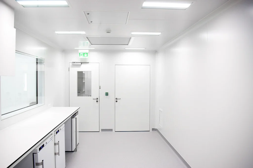 Interior of a SteriCube mobile cleanroom with cleanable wall panels, workbench and door