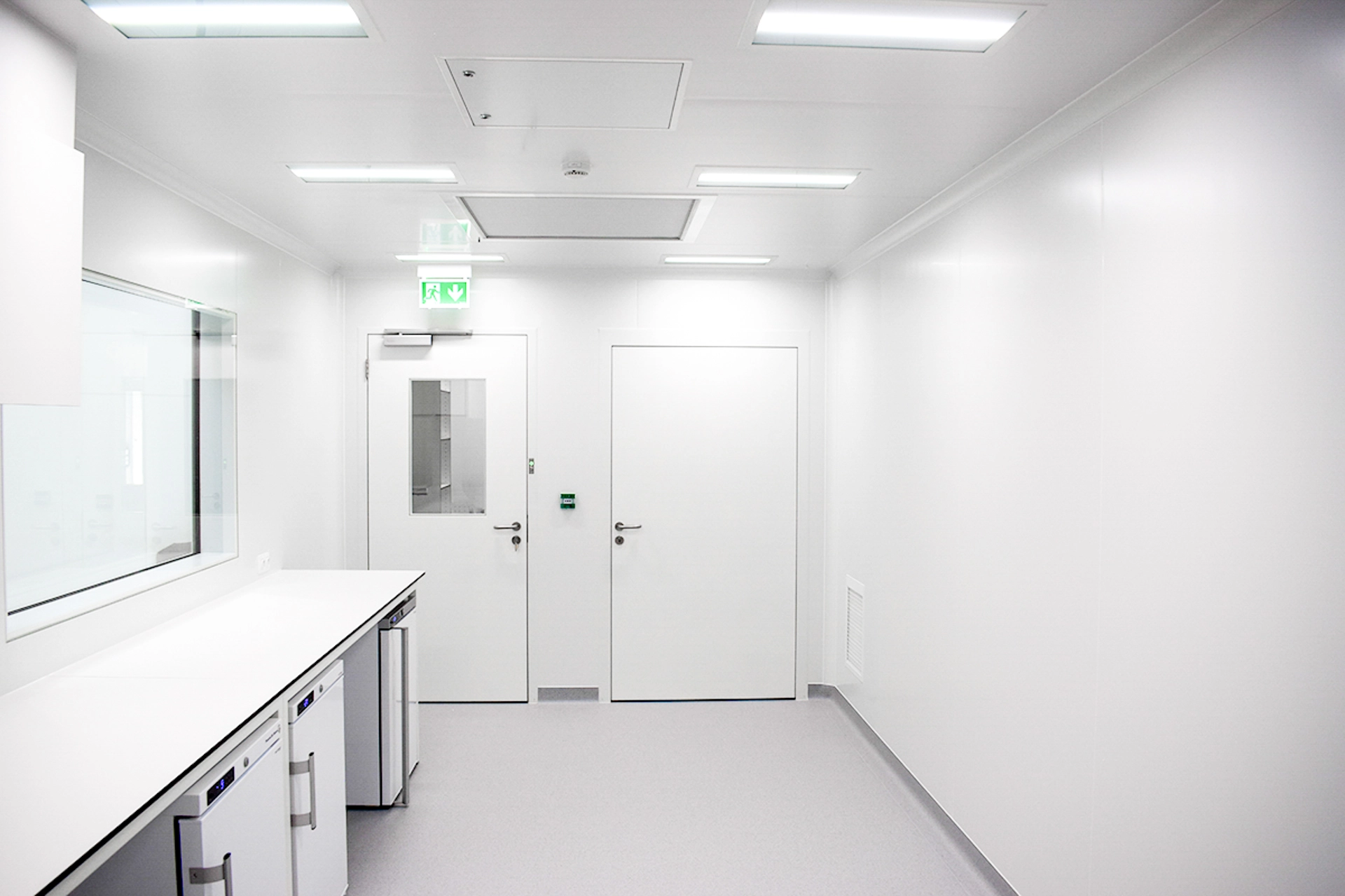 Interior of a SteriCube mobile cleanroom with cleanable wall panels, workbench and door